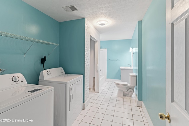 2215 W Jefferson St, Louisville, KY 40212 - washroom featuring independent washer and dryer, light tile patterned flooring, and a textured ceiling