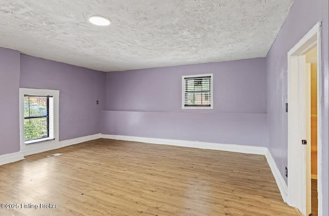 2215 W Jefferson St, Louisville, KY 40212 - spare room featuring wood finished floors, plenty of natural light, and a textured ceiling