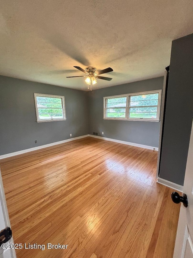 2707 Sharon Way, Louisville, KY 40220 - empty room with a textured ceiling, light wood finished floors, plenty of natural light, and a ceiling fan