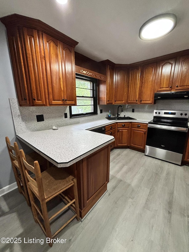 2707 Sharon Way, Louisville, KY 40220 - kitchen with stainless steel range with electric cooktop, extractor fan, a peninsula, light wood-style flooring, and a kitchen breakfast bar