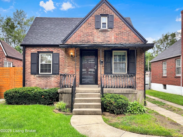 2406 Bradley Ave, Louisville, KY 40217 - view of front facade featuring brick siding, covered porch, and a shingled roof