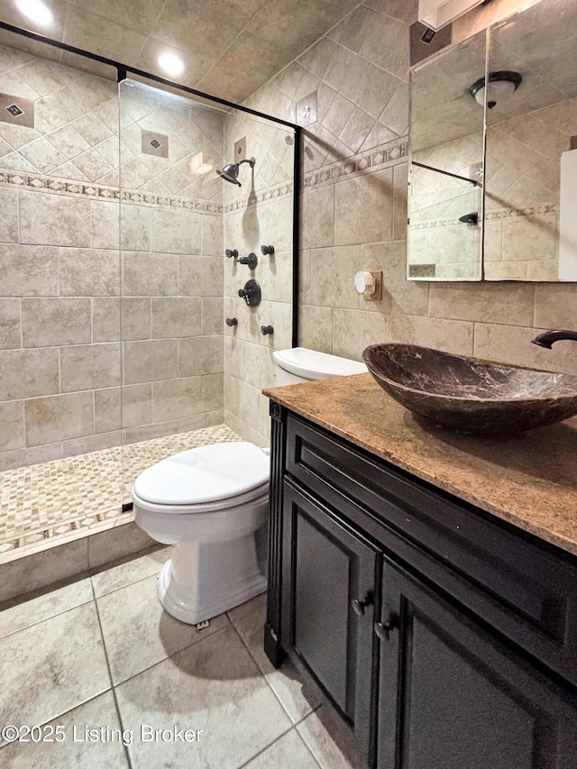 2406 Bradley Ave, Louisville, KY 40217 - bathroom featuring vanity, tile walls, tiled shower, and tile patterned flooring