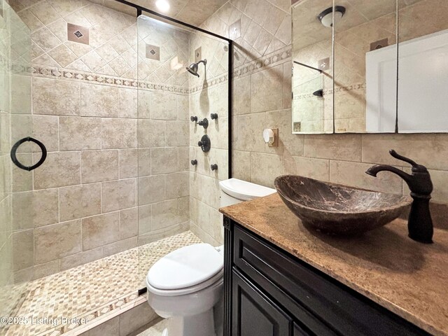 2406 Bradley Ave, Louisville, KY 40217 - bathroom featuring a shower stall, vanity, decorative backsplash, and tile walls