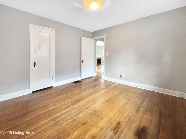 2406 Bradley Ave, Louisville, KY 40217 - empty room featuring light wood-type flooring and arched walkways