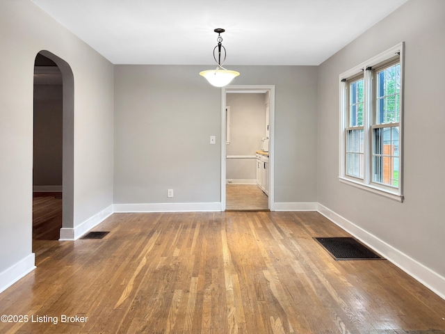 2406 Bradley Ave, Louisville, KY 40217 - unfurnished dining area with arched walkways and wood finished floors