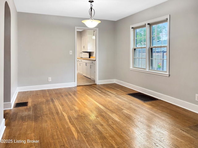 2406 Bradley Ave, Louisville, KY 40217 - empty room with hardwood / wood-style floors and arched walkways