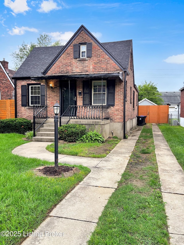2406 Bradley Ave, Louisville, KY 40217 - bungalow-style home with brick siding, covered porch, and a shingled roof