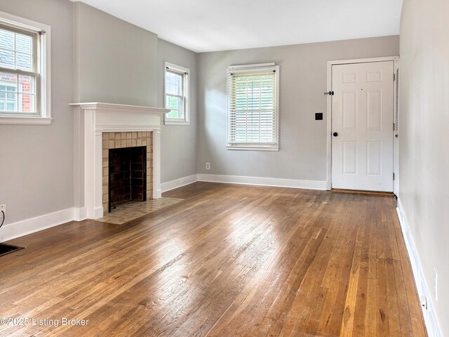 2406 Bradley Ave, Louisville, KY 40217 - unfurnished living room with hardwood / wood-style flooring and a tile fireplace
