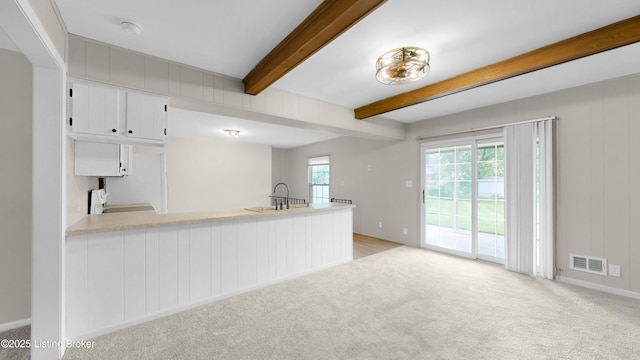 2204 Renown Dr, Jeffersontown, KY 40299 - kitchen with light colored carpet, beamed ceiling, a peninsula, white cabinets, and light countertops