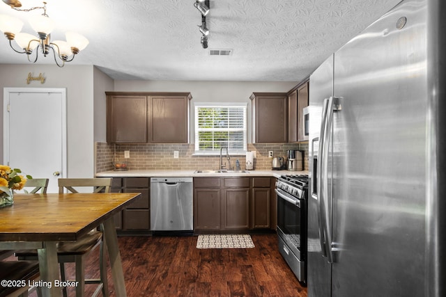 9511 Arrowridge Dr, Louisville, KY 40229 - kitchen with stainless steel appliances, dark wood-type flooring, light countertops, a chandelier, and a textured ceiling