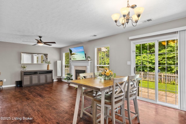 9511 Arrowridge Dr, Louisville, KY 40229 - dining area with a fireplace, a chandelier, wood finished floors, a textured ceiling, and a ceiling fan