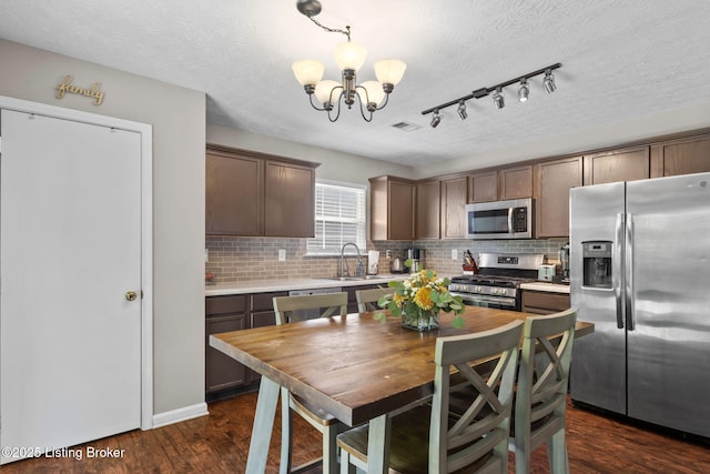 9511 Arrowridge Dr, Louisville, KY 40229 - kitchen with appliances with stainless steel finishes, a chandelier, light countertops, tasteful backsplash, and a textured ceiling