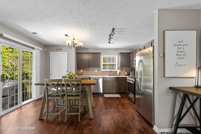 9511 Arrowridge Dr, Louisville, KY 40229 - kitchen with appliances with stainless steel finishes, light countertops, tasteful backsplash, dark wood finished floors, and a chandelier