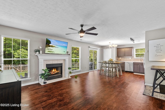 9511 Arrowridge Dr, Louisville, KY 40229 - living area featuring dark wood-type flooring, a ceiling fan, a tile fireplace, plenty of natural light, and a textured ceiling
