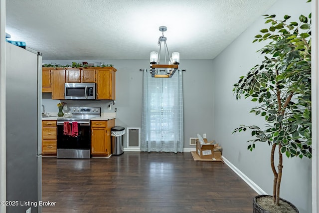6102 Dalia Ct, Louisville, KY 40272 - kitchen with appliances with stainless steel finishes, light countertops, a chandelier, dark wood-style floors, and a textured ceiling