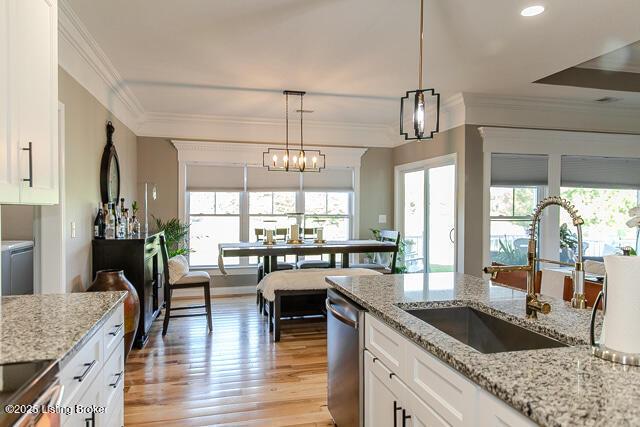 2370 N Borcherding Rd, Madison, IN 47250 - kitchen with dishwasher, white cabinetry, hanging light fixtures, ornamental molding, and light wood-style floors