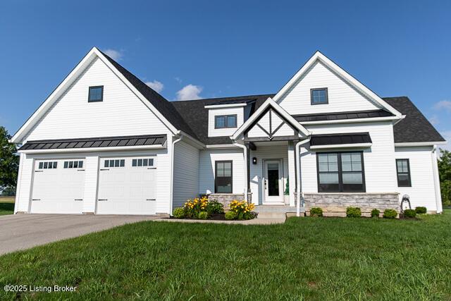 2370 N Borcherding Rd, Madison, IN 47250 - view of front of home with stone siding, a front lawn, driveway, a standing seam roof, and a metal roof