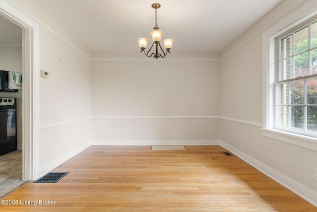 1669 Trigg St, Louisville, KY 40213 - unfurnished dining area with light wood-style floors, plenty of natural light, and a chandelier
