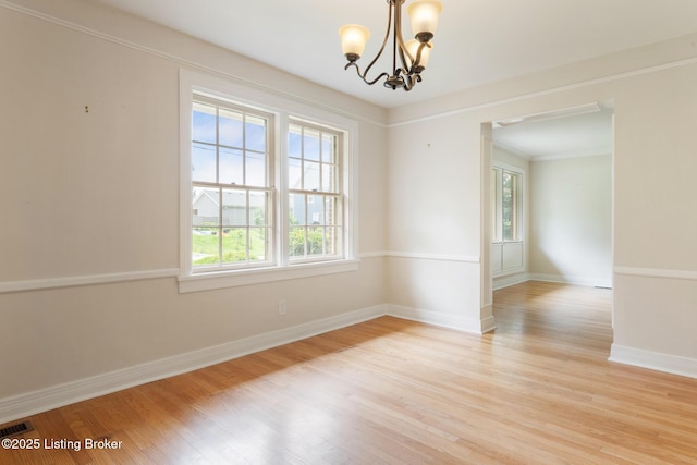 1669 Trigg St, Louisville, KY 40213 - unfurnished room featuring light wood-style flooring, a chandelier, and ornamental molding