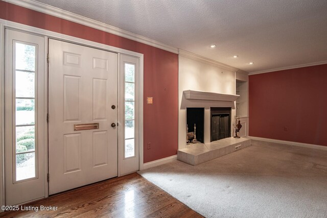 107 Westwood Dr, Elizabethtown, KY 42701 - entrance foyer with crown molding, wood finished floors, a tile fireplace, a textured ceiling, and recessed lighting