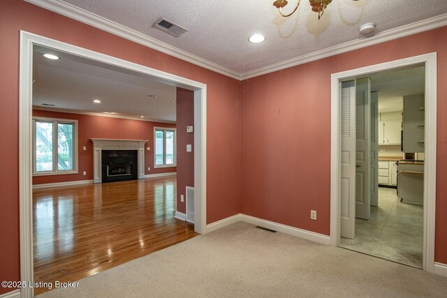 107 Westwood Dr, Elizabethtown, KY 42701 - unfurnished living room with plenty of natural light, light carpet, crown molding, a fireplace, and a textured ceiling