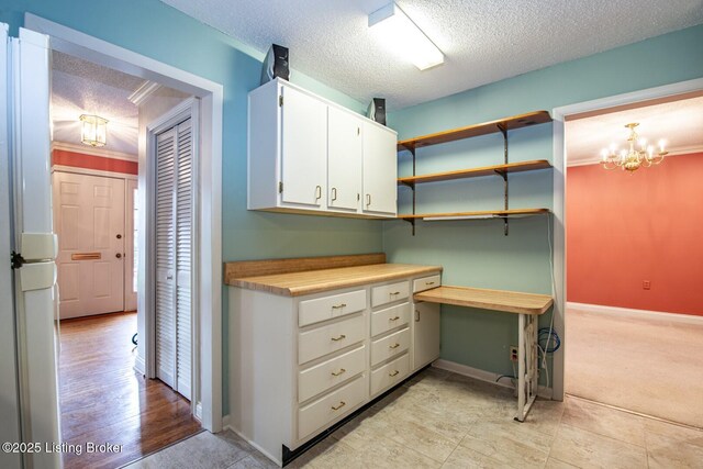 107 Westwood Dr, Elizabethtown, KY 42701 - interior space featuring a textured ceiling, white cabinets, a chandelier, light countertops, and freestanding refrigerator