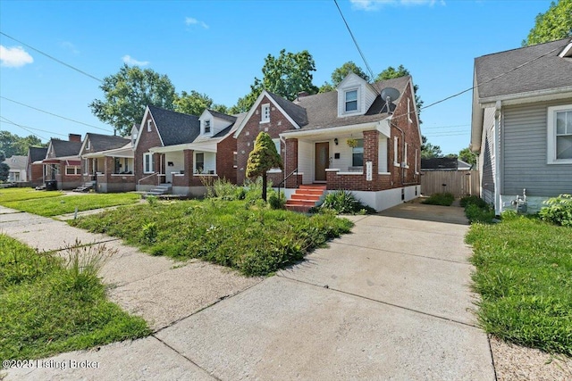 1120 Dresden Ave, Louisville, KY 40215 - view of front of home featuring brick siding, covered porch, and concrete driveway