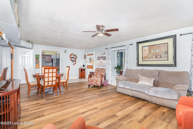 4906 Roman Dr, Louisville, KY 40291 - living room with light wood finished floors, a ceiling fan, and a textured ceiling