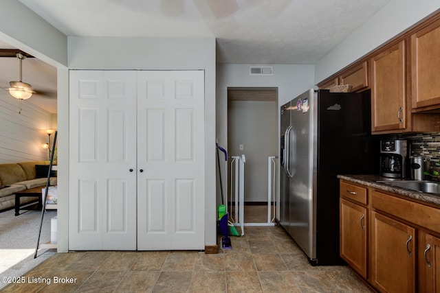 4606 Haeringdon Dr, Jeffersontown, KY 40299 - kitchen with dark countertops, brown cabinets, stainless steel refrigerator with ice dispenser, tasteful backsplash, and stone finish flooring