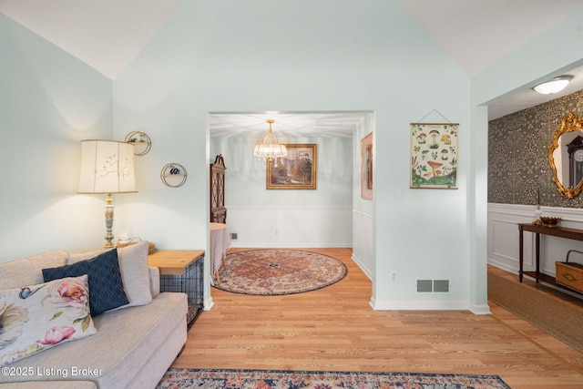 7813 Delightful Way, Louisville, KY 40291 - living room featuring vaulted ceiling, wood finished floors, a wainscoted wall, and a chandelier