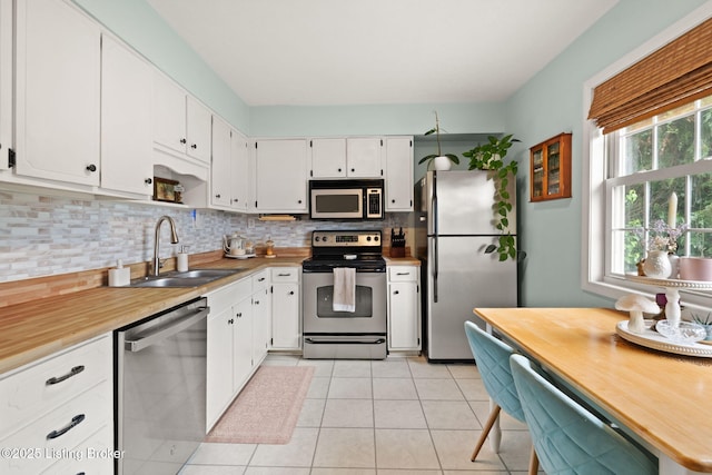 7813 Delightful Way, Louisville, KY 40291 - kitchen featuring appliances with stainless steel finishes, tasteful backsplash, light tile patterned floors, and white cabinets