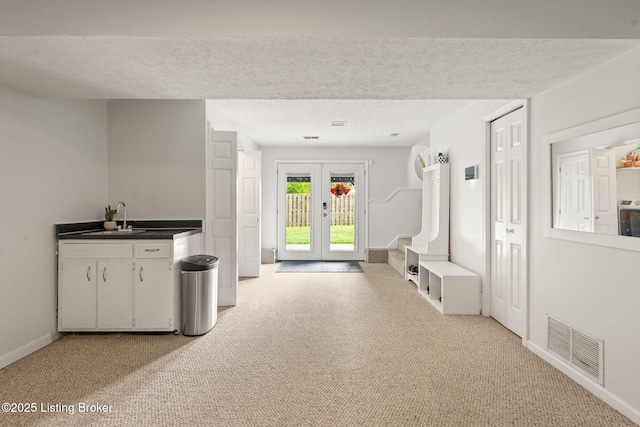 7813 Delightful Way, Louisville, KY 40291 - kitchen with a textured ceiling, french doors, dark countertops, light carpet, and white cabinets
