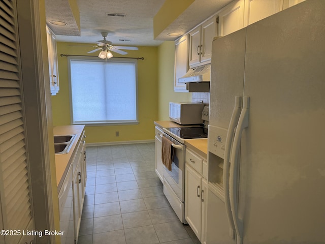 487 Piping Rock Rd, Brandenburg, KY 40108 - kitchen with white appliances, under cabinet range hood, light countertops, white cabinets, and light tile patterned floors