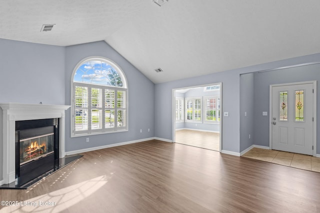 4331 Ivy Crest Cir, Louisville, KY 40241 - unfurnished living room featuring vaulted ceiling, wood finished floors, and a glass covered fireplace