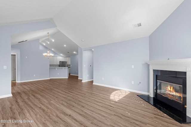 4331 Ivy Crest Cir, Louisville, KY 40241 - unfurnished living room featuring a chandelier, a glass covered fireplace, light wood-type flooring, and lofted ceiling