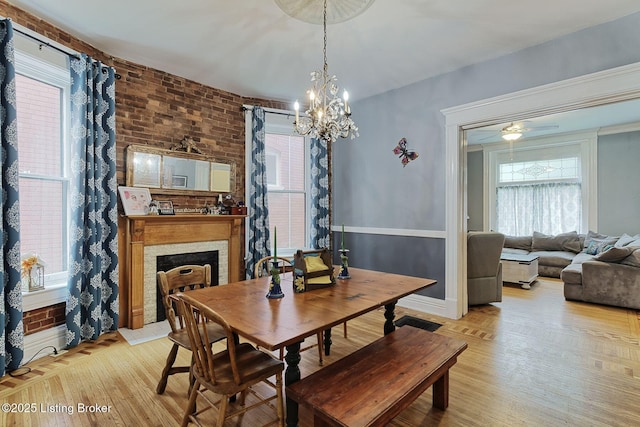 1331 Highland Ave, Louisville, KY 40204 - dining room featuring healthy amount of natural light, a chandelier, light wood-style flooring, and brick wall