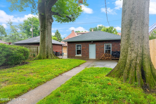 2144 Baringer Ave, Louisville, KY 40204 - back of property featuring brick siding, roof with shingles, a patio area, and a chimney