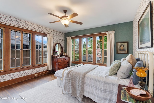 2144 Baringer Ave, Louisville, KY 40204 - bedroom featuring wallpapered walls, wood finished floors, multiple windows, and ceiling fan