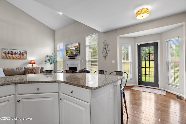3903 Zaring Mill Ct, Louisville, KY 40241 - kitchen with a high end fireplace, a breakfast bar, white cabinets, hardwood / wood-style flooring, and open floor plan