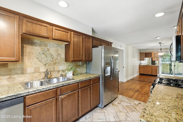 335 Ridgeway Ave, Louisville, KY 40207 - kitchen featuring appliances with stainless steel finishes, backsplash, brown cabinetry, light stone countertops, and recessed lighting