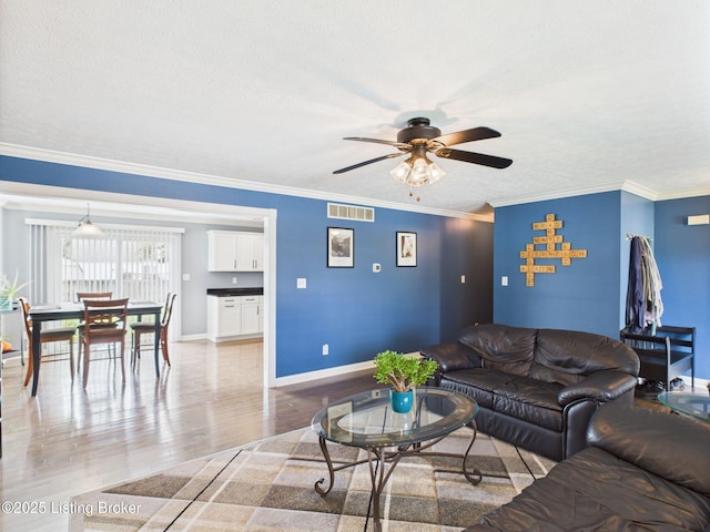 6408 Autumn Oak Way, Louisville, KY 40272 - living room with a ceiling fan, light wood-type flooring, a textured ceiling, and crown molding