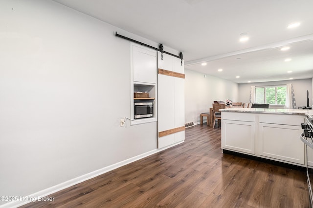 609 Lynn Rd, New Albany, IN 47150 - kitchen featuring dark wood finished floors, a barn door, white cabinets, stainless steel microwave, and recessed lighting