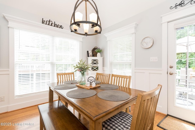 3511 Hardwood Forest Dr, Louisville, KY 40214 - dining room featuring a decorative wall, light wood finished floors, a chandelier, and wainscoting