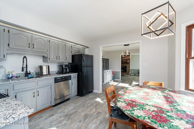 570 Sulphur Rd, Smiths Grove, KY 42171 - kitchen with stainless steel dishwasher, freestanding refrigerator, light wood-style floors, gray cabinetry, and decorative light fixtures