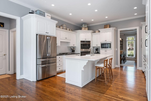12812 Ridgemoor Dr, Prospect, KY 40059 - kitchen with appliances with stainless steel finishes, backsplash, dark wood-style floors, a kitchen island with sink, and white cabinets