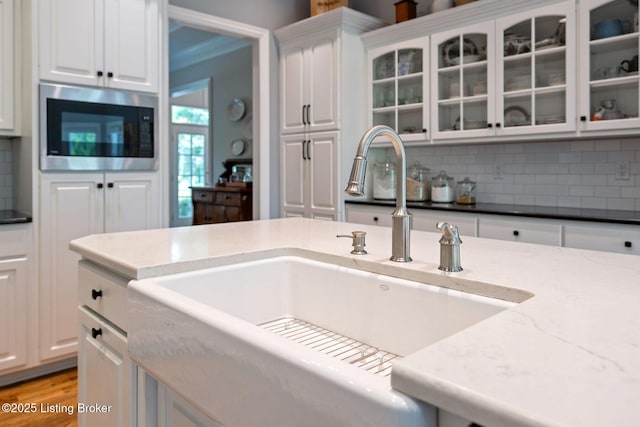 12812 Ridgemoor Dr, Prospect, KY 40059 - kitchen with stainless steel microwave, white cabinetry, and tasteful backsplash