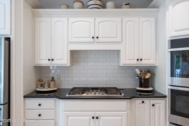 12812 Ridgemoor Dr, Prospect, KY 40059 - kitchen featuring appliances with stainless steel finishes, dark countertops, tasteful backsplash, white cabinetry, and crown molding