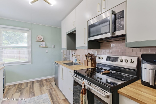 1301 Mark Trail Rd, Louisville, KY 40242 - kitchen featuring stainless steel appliances, backsplash, light wood-style floors, white cabinetry, and ornamental molding