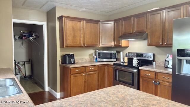 360 Grant Ridge Rd, Leitchfield, KY 42754 - kitchen featuring stainless steel appliances, under cabinet range hood, light countertops, and brown cabinetry
