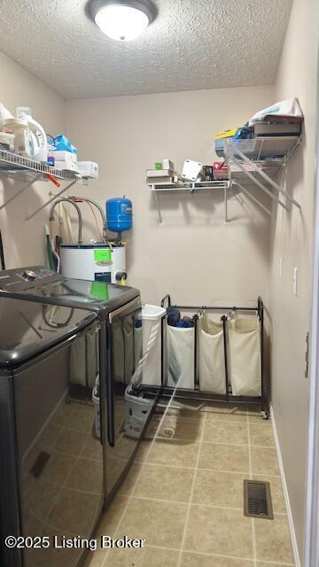 360 Grant Ridge Rd, Leitchfield, KY 42754 - washroom featuring a textured ceiling, separate washer and dryer, water heater, and light tile patterned flooring